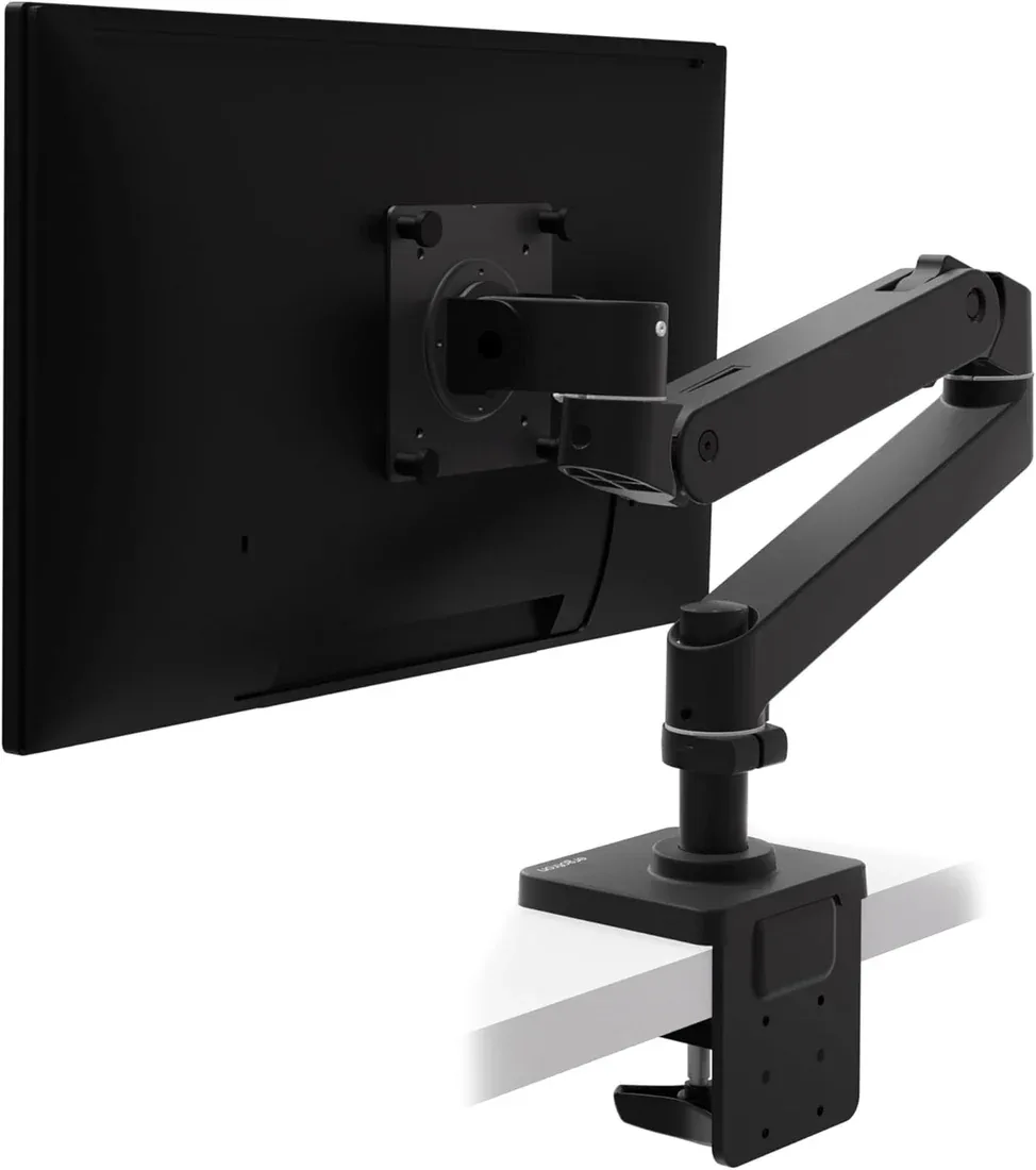 Black Ergotron LX Pro monitor arm clamped to a desk, shown from behind the monitor